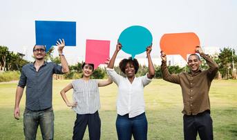 Four people of different ethnicity holding speech bubbles or callouts